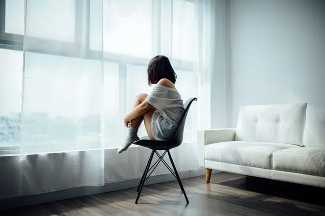 woman on a chair looking over her window