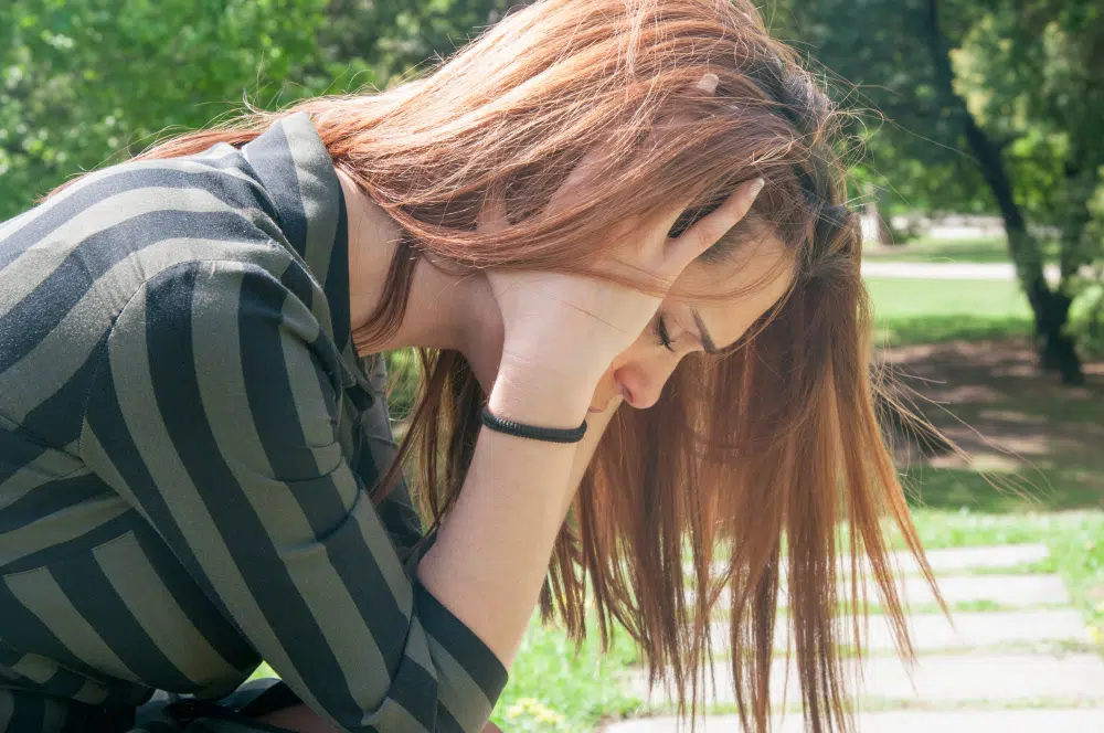 Depressed girl sitting on a bench park