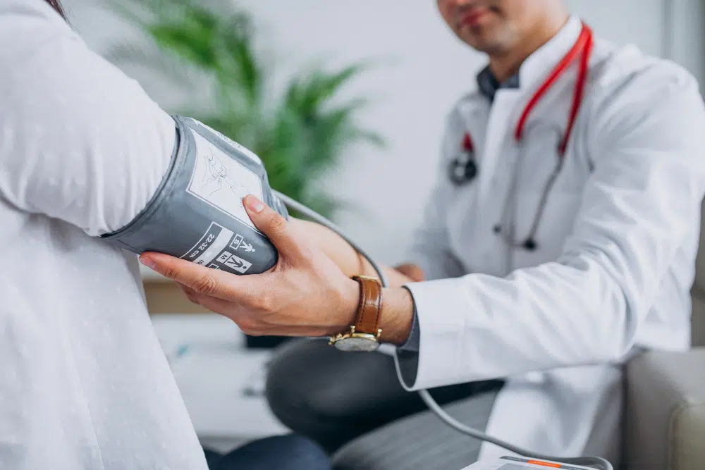 young male physician with patient measuring blood pressure