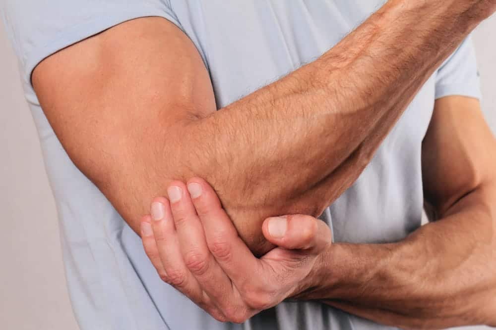 man holding his elbow in pain