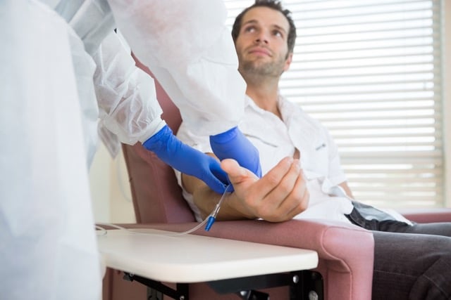 Male patient looking at nurse while receiving a ketamine treatment in hospital room