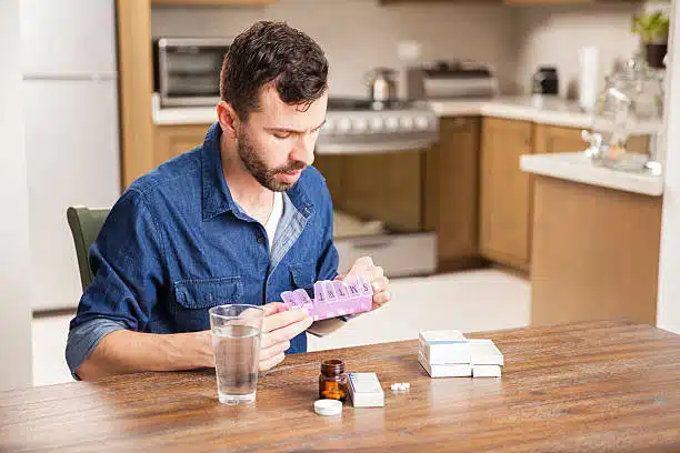 Man sorting his tablets medicine for Hormone Replacement Therapy