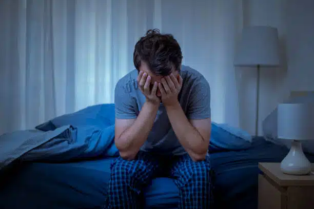 Depressed man at night having trouble on sleeping.