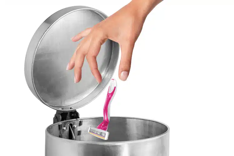 Woman throwing her shaver in the trashcan.