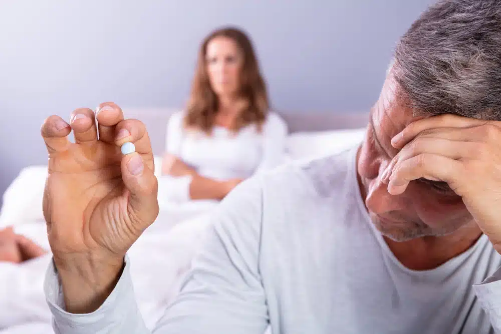 Man with a Erectile Dysfunction holding a tablet medicine.