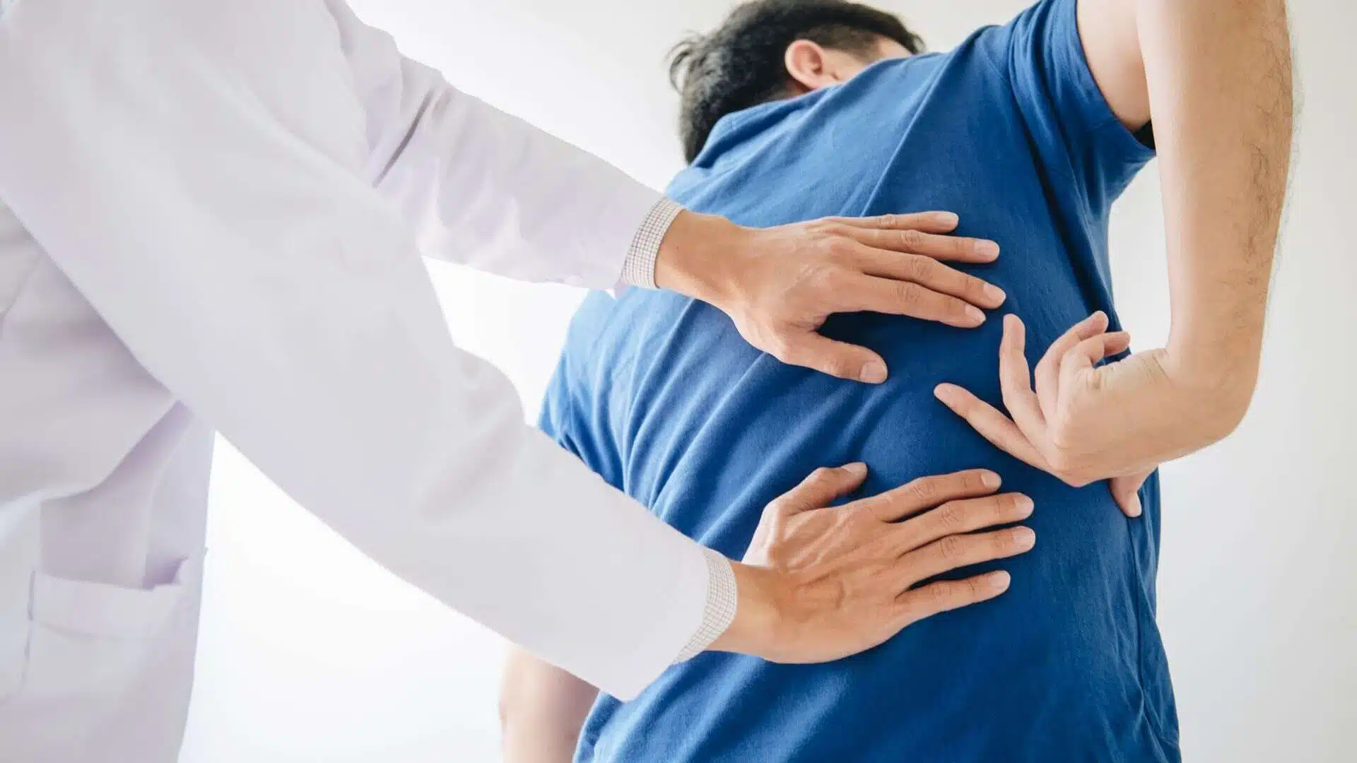 Physiologist Checking Men Athlete with Back Injury